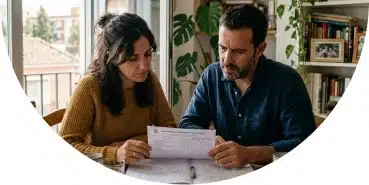 Padres revisando documentos escolares en casa en Sevilla